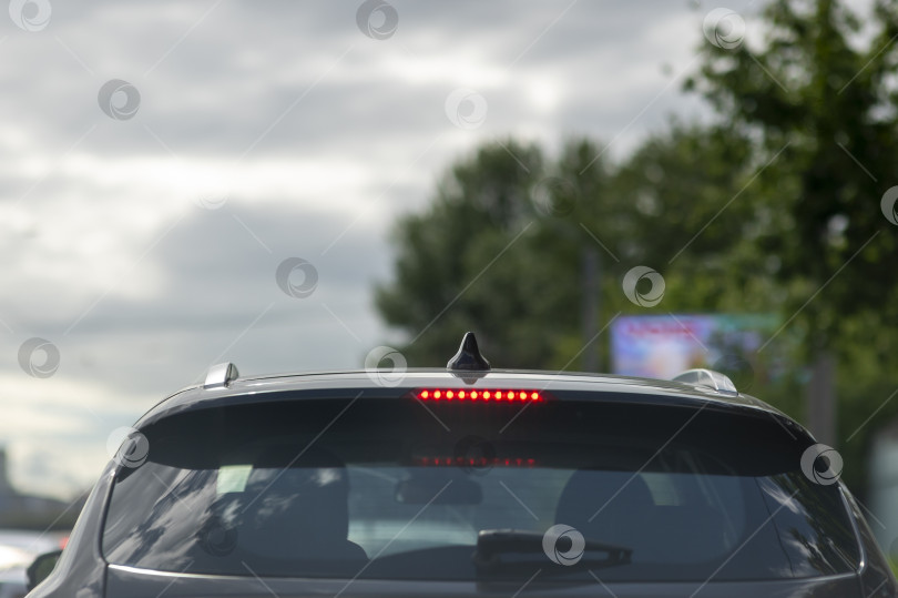 Скачать Темная крыша автомобиля на городской улице в Санкт-Петербурге, июнь 2026 года, глянцево-черная и детализированная крупным планом, отражающая исторические здания и летнее небо белых ночей над головой. фотосток Ozero