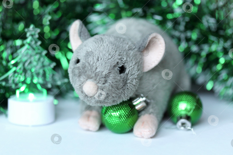 Скачать Симпатичная мягкая игрушка в виде крысы или мышки с зелеными украшениями и мишурой фотосток Ozero
