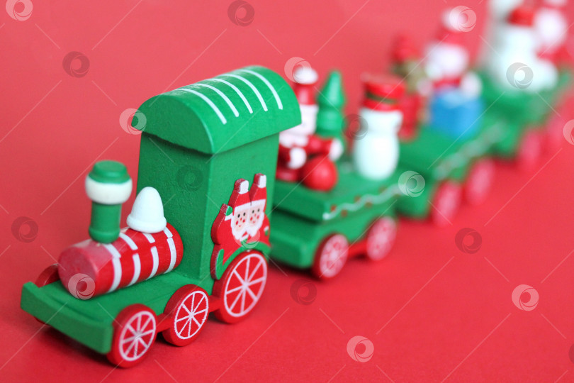 Скачать Зеленый праздничный деревянный поезд на красном фоне фотосток Ozero