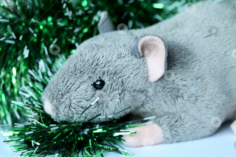 Скачать Симпатичная мягкая игрушка в виде крысы или мышки с зеленой мишурой фотосток Ozero