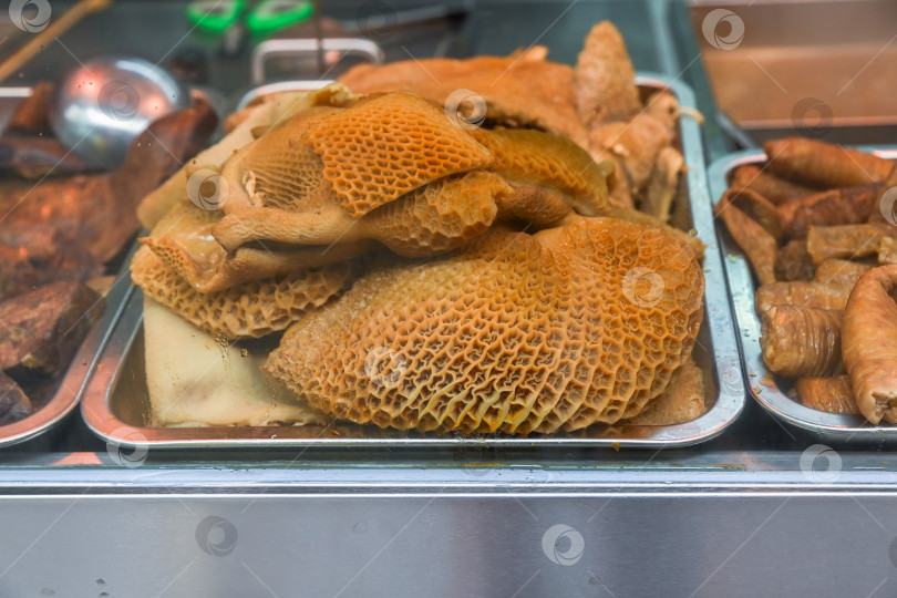 Скачать Крупный план тушеных говяжьих субпродуктов по-кантонски с рубцом в виде сот в киоске уличной еды на знаменитой пешеходной улице Руа-ду-Кунья в деревне Тайпа в Макао. фотосток Ozero