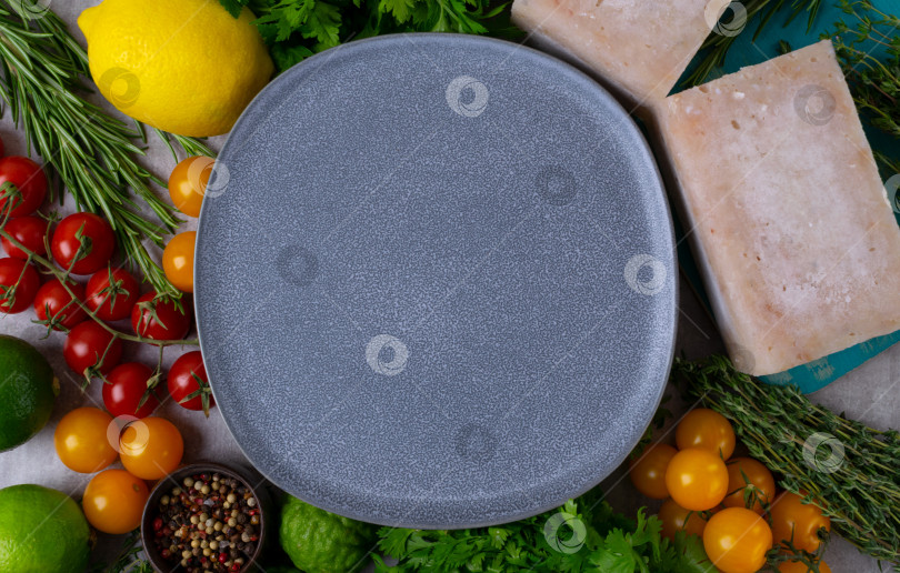 Скачать Свежие продукты разложены вокруг пустой серой тарелки на светлом фоне фотосток Ozero