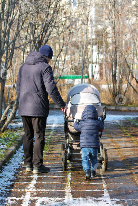 Скачать Маленький ребенок гуляет со своим отцом и братом в коляске фотосток Ozero