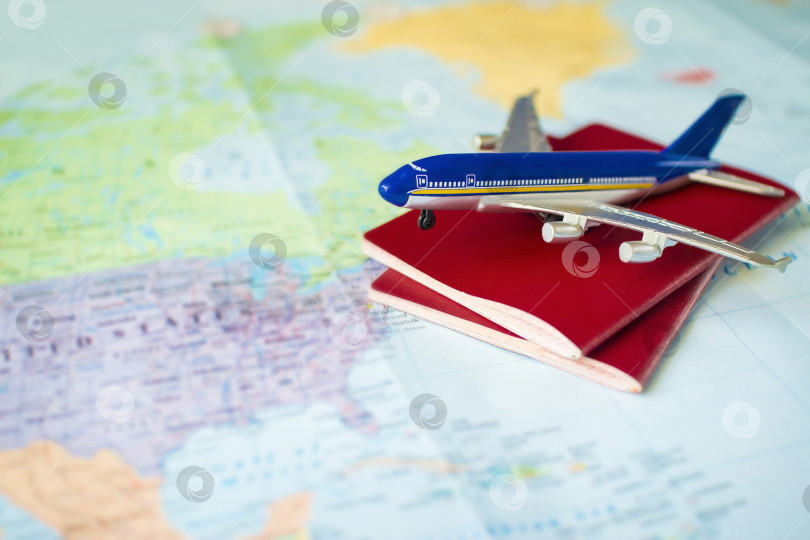 Скачать игрушечный самолет с двумя паспортами на карте, концепция путешествия. фотосток Ozero