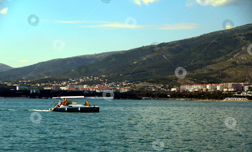 Скачать Катер в Черном море на фоне гор и Геленджика. фотосток Ozero