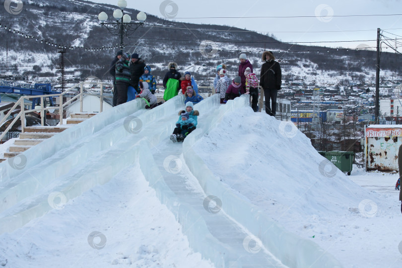 Скачать Магадан, Россия - декабрь 2019 года. Люди на большой ледяной горке, сделанной из снега фотосток Ozero