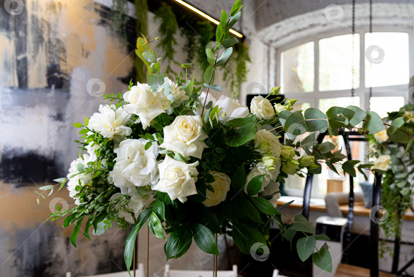Скачать Красивый букет белых роз в вазе. Свадебное украшение. Потрясающий букет белых роз в вазе, идеально подобранный для украшения свадебной церемонии в помещении свежей красотой природы. фотосток Ozero