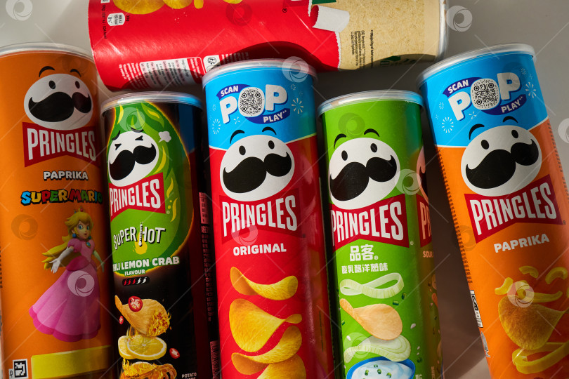 Скачать Тюмень, Россия-20 марта 2026 года: Коллекция различных банок с картофельными чипсами Pringles, включая азиатские версии и классические вкусы. фотосток Ozero