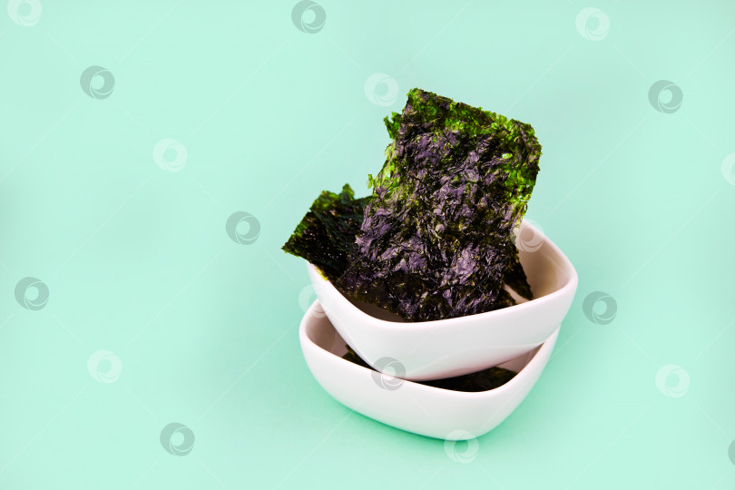 Скачать Хрустящие водоросли нори разложить по тарелкам. Традиционные японские сухие листы из морских водорослей фотосток Ozero