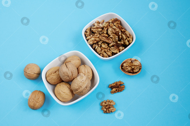 Скачать Ядра грецких орехов в вазочках на синем фоне. фотосток Ozero