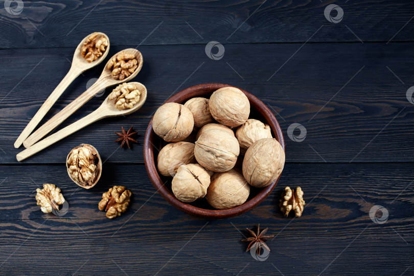 Скачать Ядра грецких орехов в миске на фоне темного дерева. фотосток Ozero