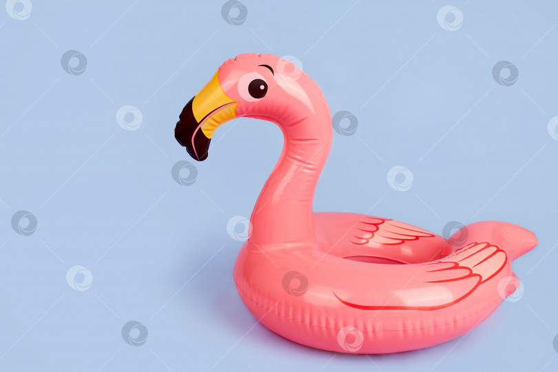 Скачать Надувной фламинго на синем фоне, пляжная игрушка. фотосток Ozero