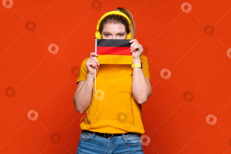 Скачать Девушка держит маленький немецкий флаг фотосток Ozero