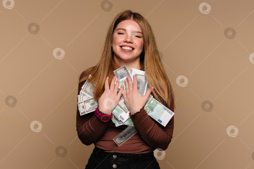 Скачать Девушка с закрытыми глазами держит пачку бумажных денег фотосток Ozero