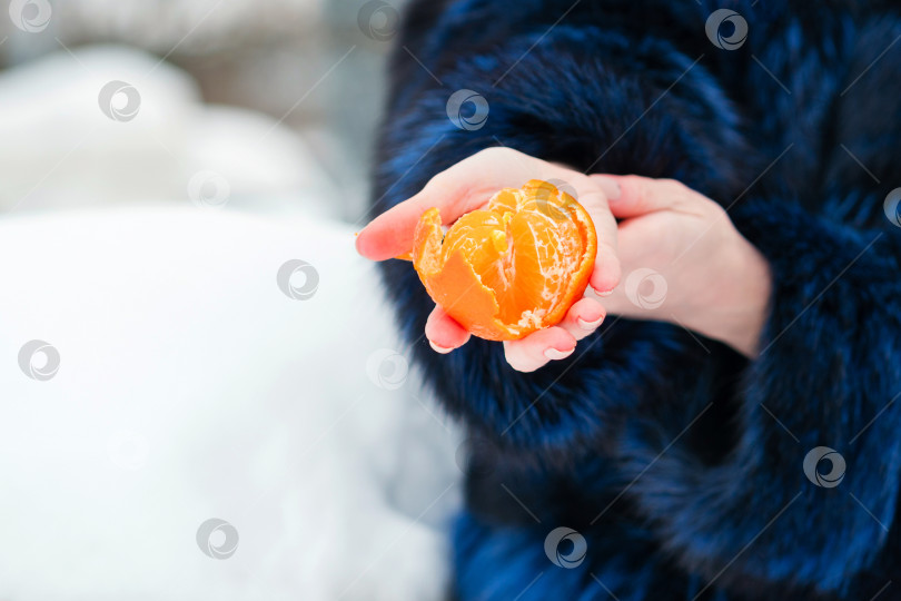 Скачать Молодая женщина показывает мандарин фотосток Ozero