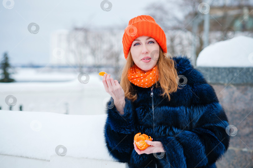 Скачать Молодая женщина наслаждается мандарином фотосток Ozero