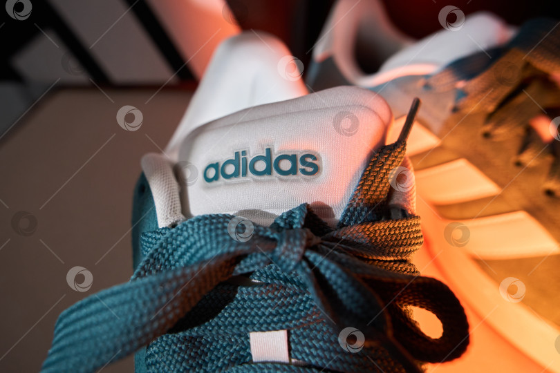 Скачать Тюмень, Россия-20 марта 2026 года: Яркая обувь adidas grand court alpha 0 стоит на поверхности в чистом помещении с простым декором. фотосток Ozero