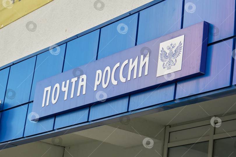 Скачать Тюмень, Россия - 6 сентября 2026 года: Вывеска Почты России на синем фасаде фотосток Ozero