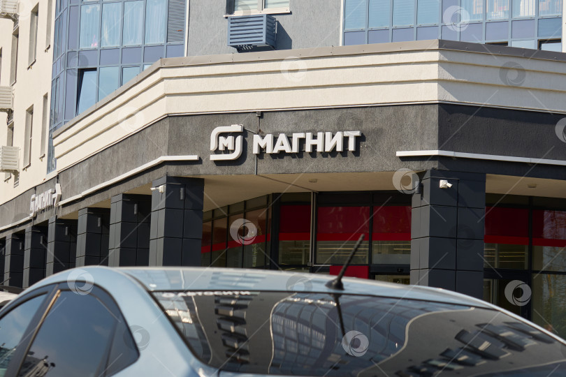 Скачать Тюмень, Россия - 6 сентября 2026 года: Фасад продуктового магазина "Магнит" со стрелкой-указателем фотосток Ozero