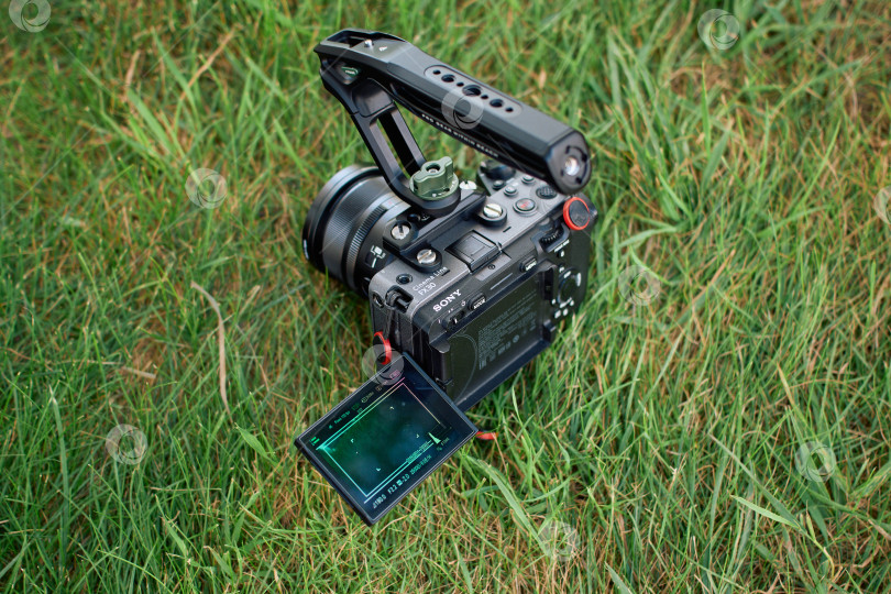 Скачать Тюмень, Россия - 10 июля 2026 года: Установка цифровой камеры Sony FX30 Cinema Line на зеленой траве фотосток Ozero