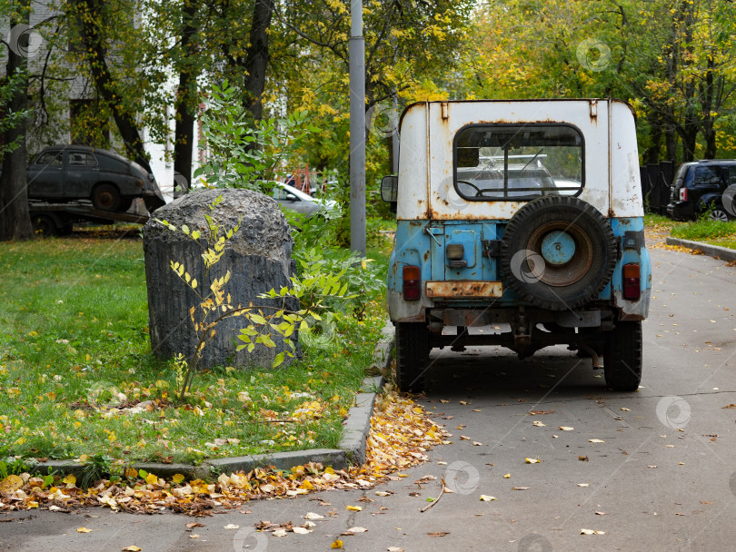 Скачать Старый ржавый внедорожник УАЗ-469 припаркован в осеннем городском дворе фотосток Ozero