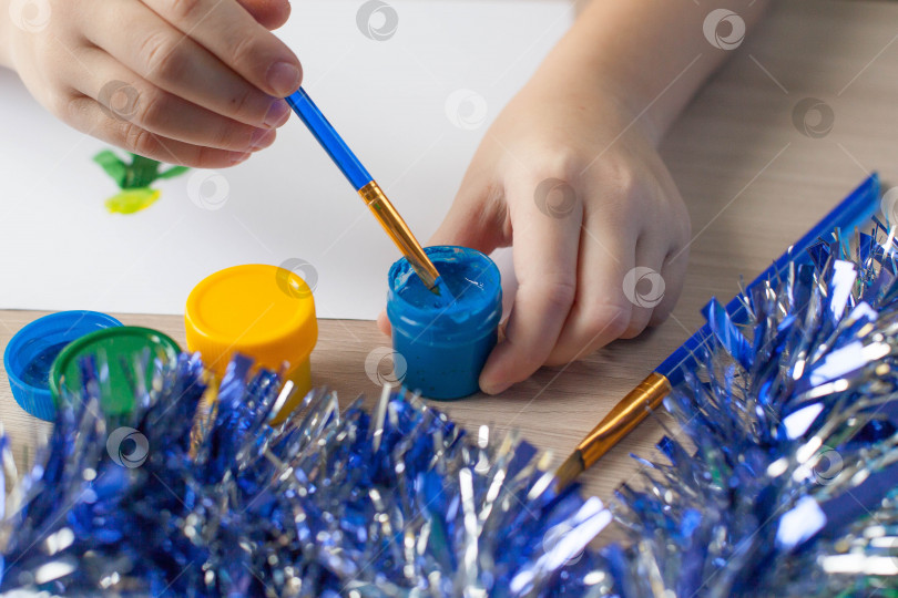 Скачать Ученический стол с инструментами для рисования и тетрадью, красками, кистями для рисования рождественской елки и снеговика. Развитие ребенка. фотосток Ozero