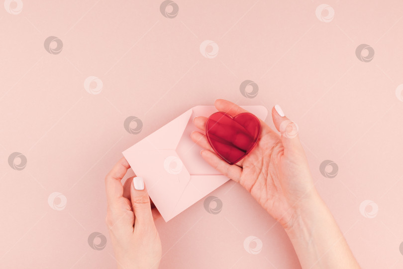 Скачать Женская рука держит маленькое розовое любовное письмо фотосток Ozero