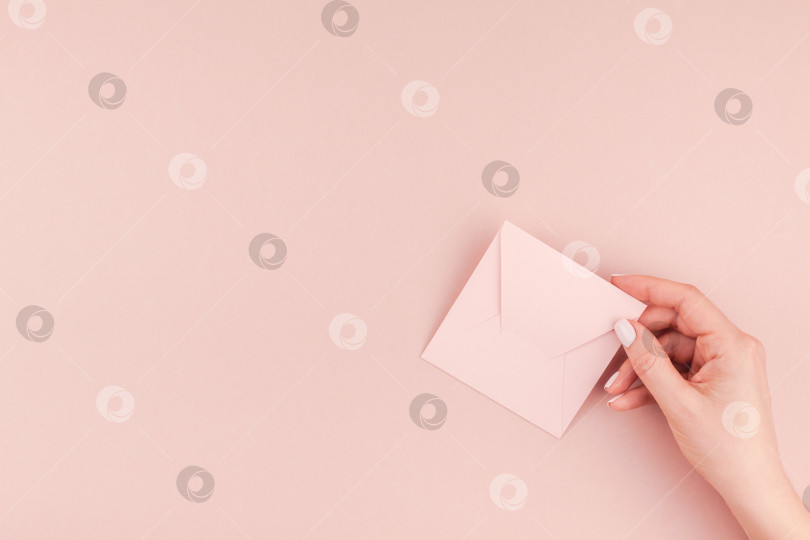 Скачать Женская рука держит маленькое розовое любовное письмо фотосток Ozero