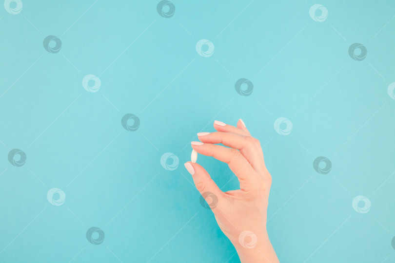 Скачать Женская рука, держащая белую таблетку фотосток Ozero