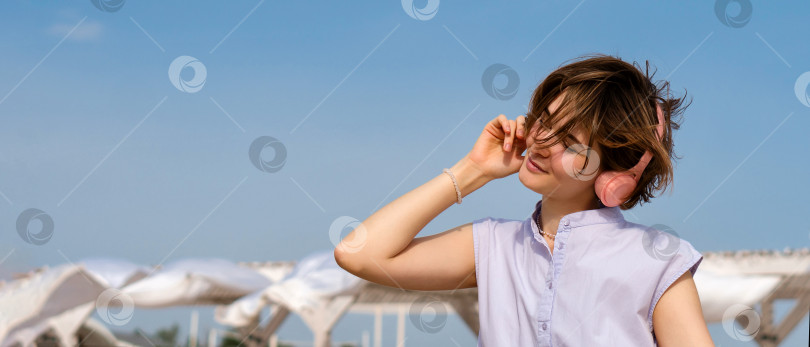 Скачать Девушка слушает музыку в наушниках на открытом воздухе фотосток Ozero