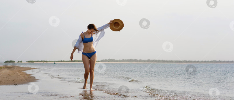 Скачать Девушка в бикини прогуливается по пляжу фотосток Ozero