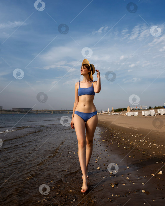 Скачать Девушка в бикини прогуливается по пляжу фотосток Ozero