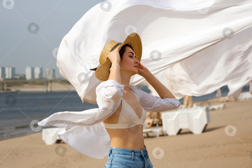 Скачать Кавказская девушка на пляже в ветреный день фотосток Ozero