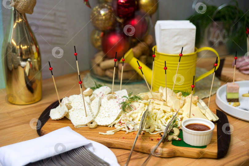 Скачать Разные сорта сыра на деревянной доске, холодные закуски на праздничном столе фотосток Ozero