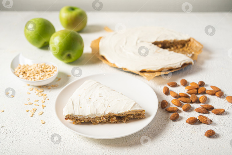 Скачать Кусочек яблочного пирога на белой тарелке с миндалем и зелеными яблоками. фотосток Ozero
