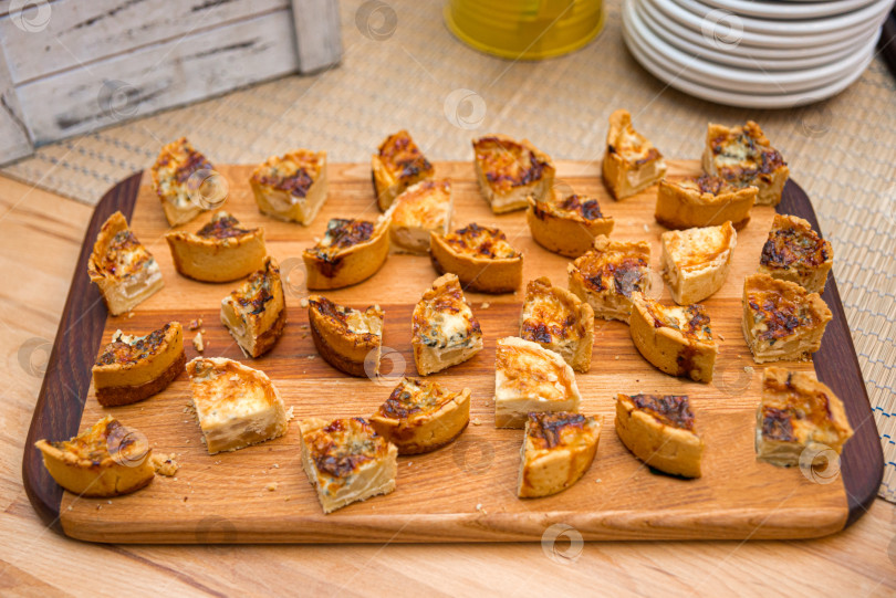 Скачать Ломтики запеченного пирога с заварным кремом с сыром и грибами на деревянной доске фотосток Ozero