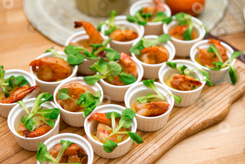 Скачать Маленькие салатики с креветками и микрозеленью в формочках на деревянной доске фотосток Ozero
