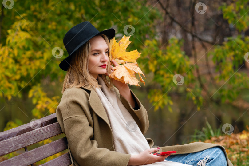 Скачать Женщина на скамейке в парке осенью фотосток Ozero