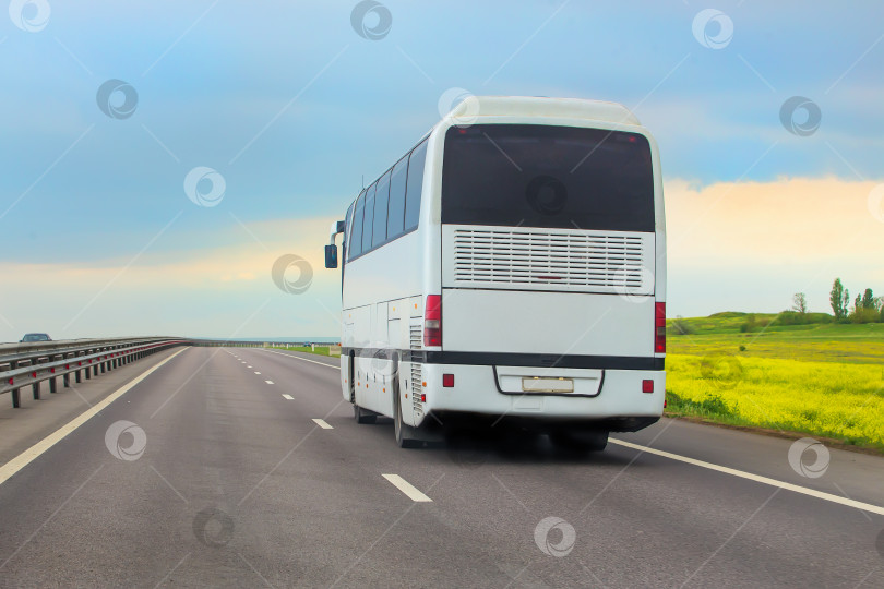 Скачать туристический автобус движется по пригородному шоссе. фотосток Ozero