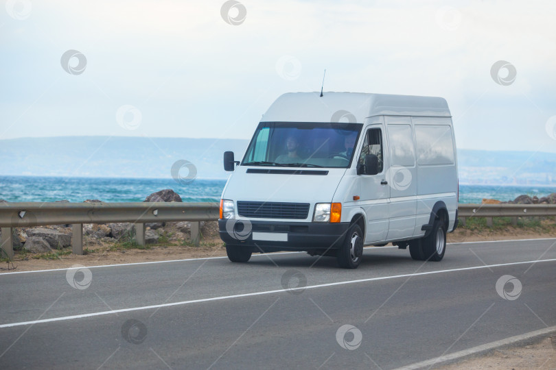 Скачать микроавтобус движется по дороге вдоль моря фотосток Ozero
