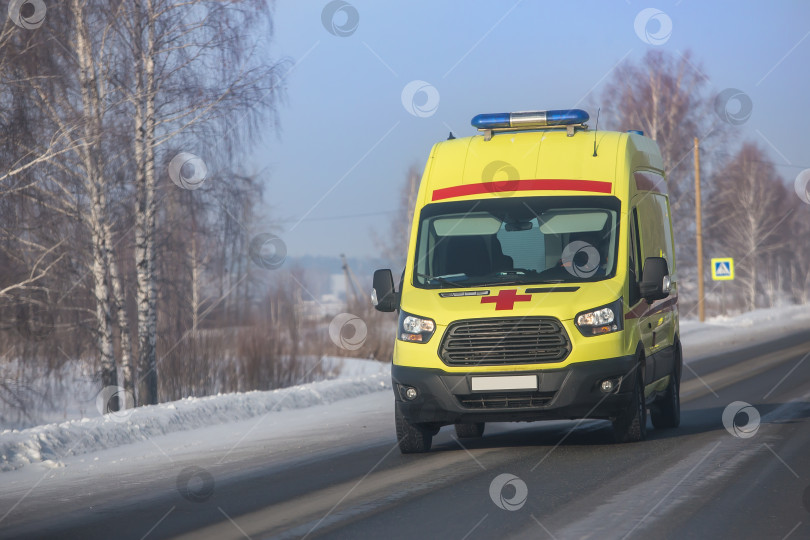 Скачать машина скорой помощи движется по дороге зимой. фотосток Ozero