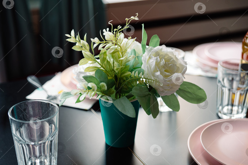 Скачать декоративные цветы в картонной вазе на столе в кафе, стол накрыт для приема пищи фотосток Ozero