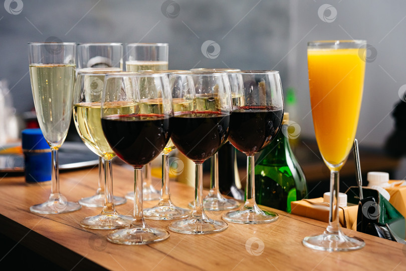 Скачать Бокалы красного и белого вина с апельсиновым соком на барной стойке. Прохладительные напитки на мероприятии. фотосток Ozero
