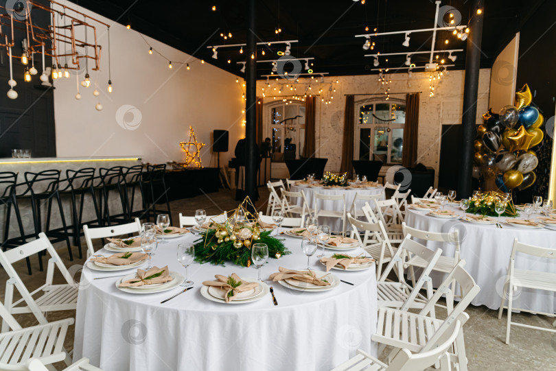 Скачать Свадебный банкетный зал с украшенным столом, стульями и теплыми лампочками на потолке фотосток Ozero
