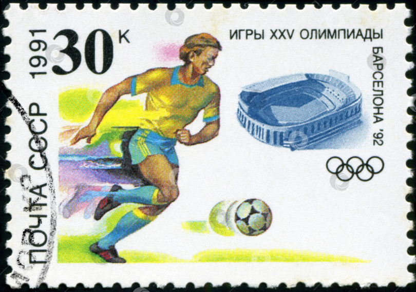 Скачать СССР - ОКОЛО 1991 года: Марка, напечатанная в СССР, футбол, soccer, Олимпийские игры в Барселоне 1992 года, игрок бьет по мячу, около 1991 года фотосток Ozero