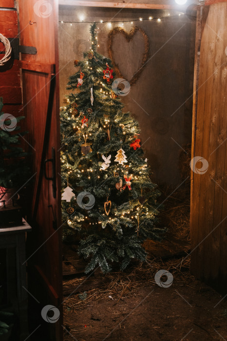Скачать время Рождества и нового года. рождественская елка, украшенная в винтажном ретро-скандинавском стиле игрушками и светящимися гирляндами. зеленая пихта или ель в сарае. зимний сезон отпусков в сельской местности фотосток Ozero