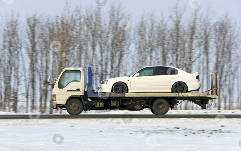 Скачать Эвакуатор везет автомобиль белого цвета фотосток Ozero