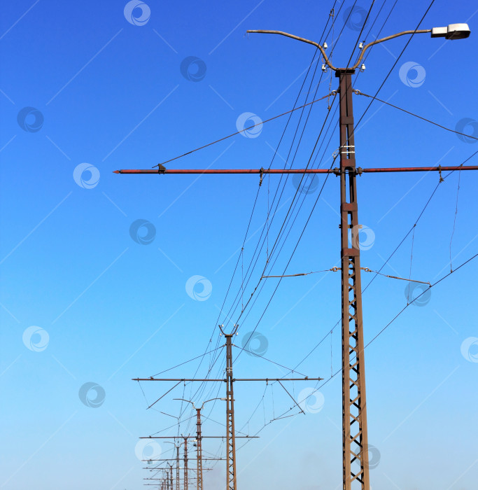 Скачать Железнодорожные линии контактной сети на фоне ясного голубого неба. фотосток Ozero