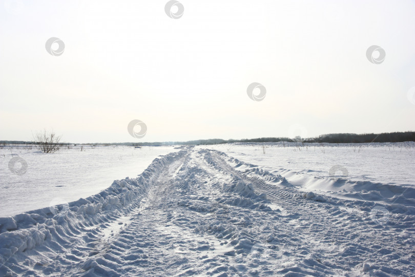 Скачать Заснеженная дорога зимой с горами вдалеке фотосток Ozero