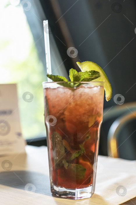 Скачать Освежающий коктейль с соломинкой на столике у окна в кафе фотосток Ozero